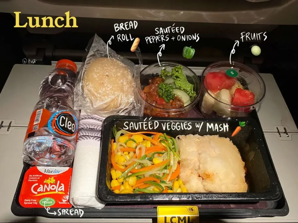 Low calorie meal lunch on Qatar Airways: Sauteed carrot, zucchini and corn, mashed potatoes, sautéed pepper side, fruit cup, bread roll and vegan spread