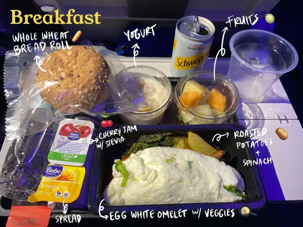 Low calorie meal breakfast on Qatar Airways: Egg white omelet. yogurt, fruit cup, whole wheat bread roll, cherry jam with stevia, and vegan spread