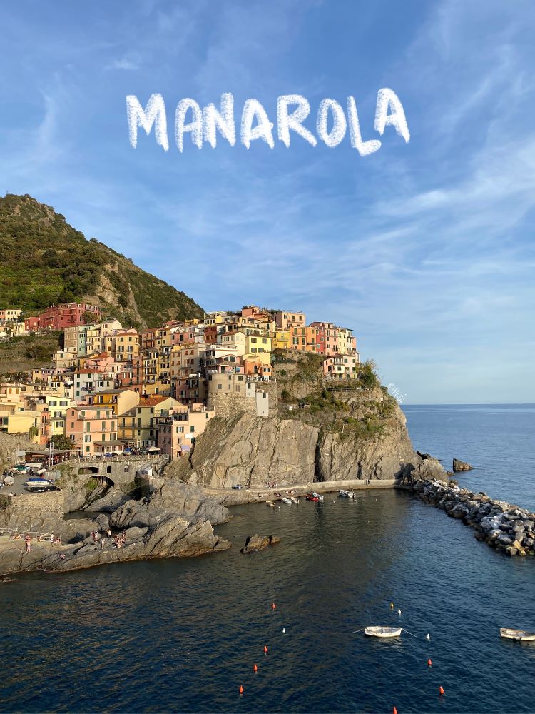 sunset view at Manarola, orange and yellow houses on top of the hill overlooking the ocean