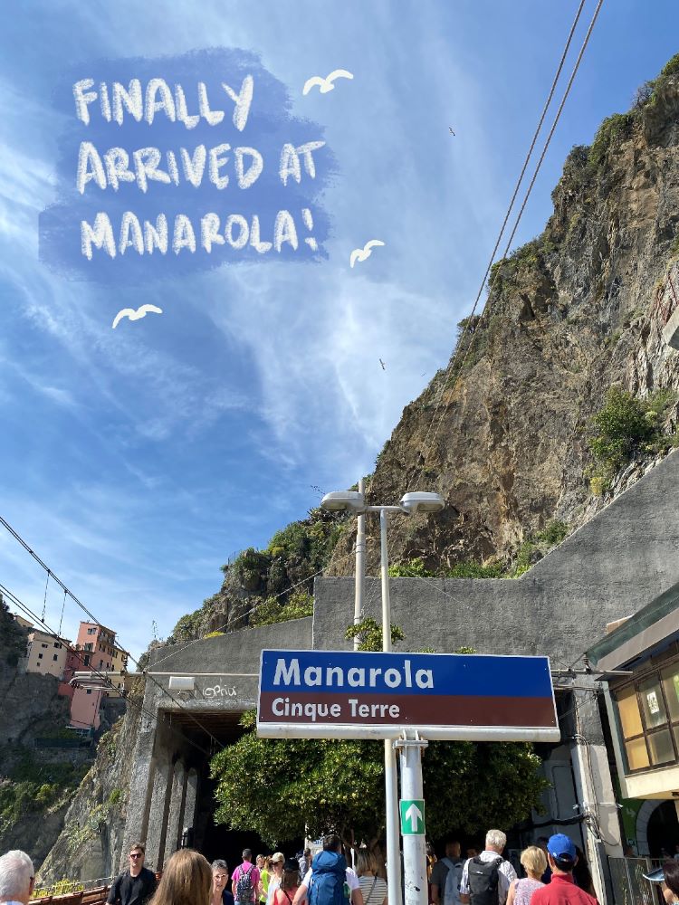 Manarola train station sign, surrounded by cliffs and the sea