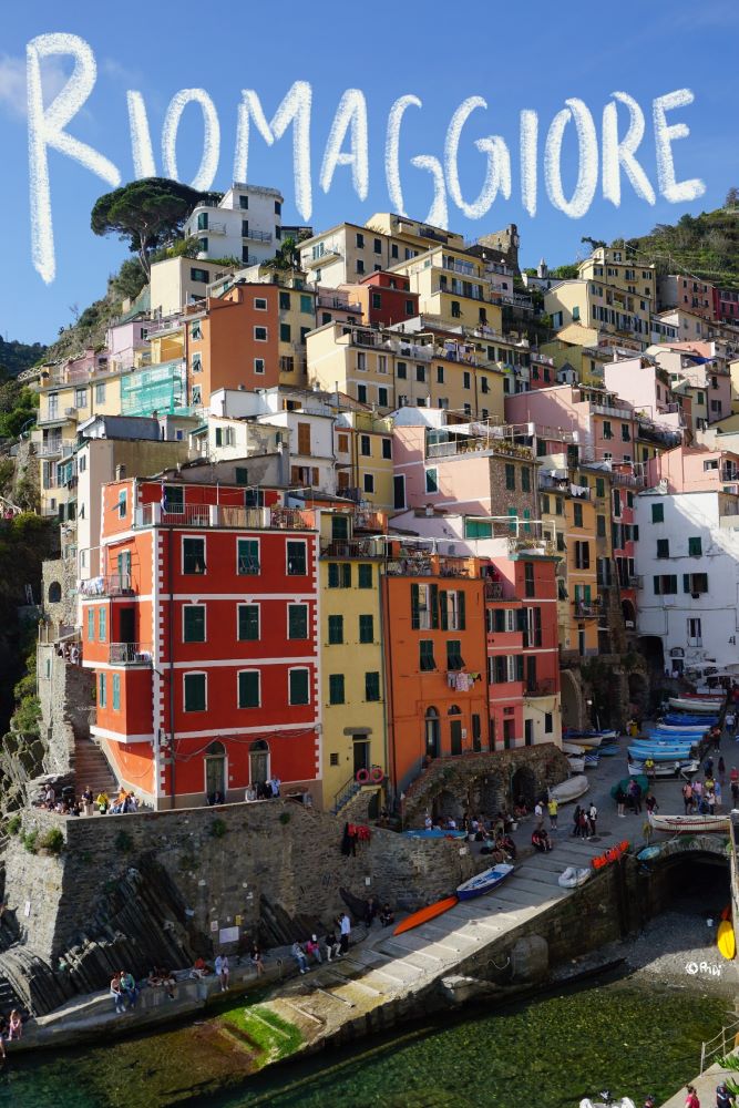 Colorful dock lined with buildings at Riomaggiore. Hues of red, yellow, orange, and white