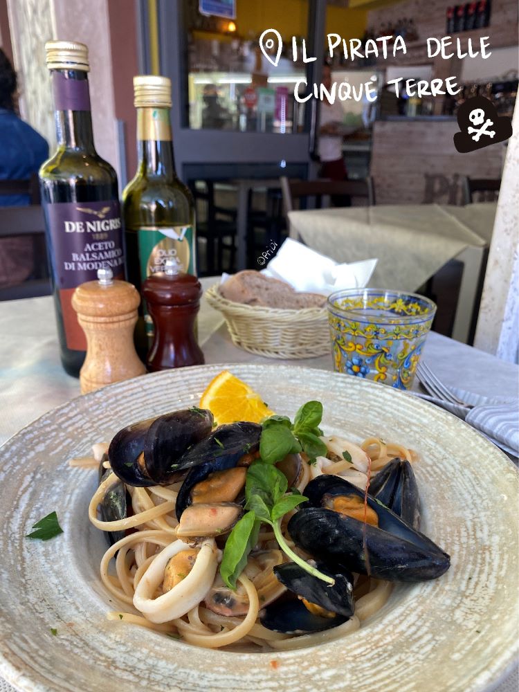 Seafood pasta and its accompanying balsamic vinegar, olive oil, pepper, and fresh bread