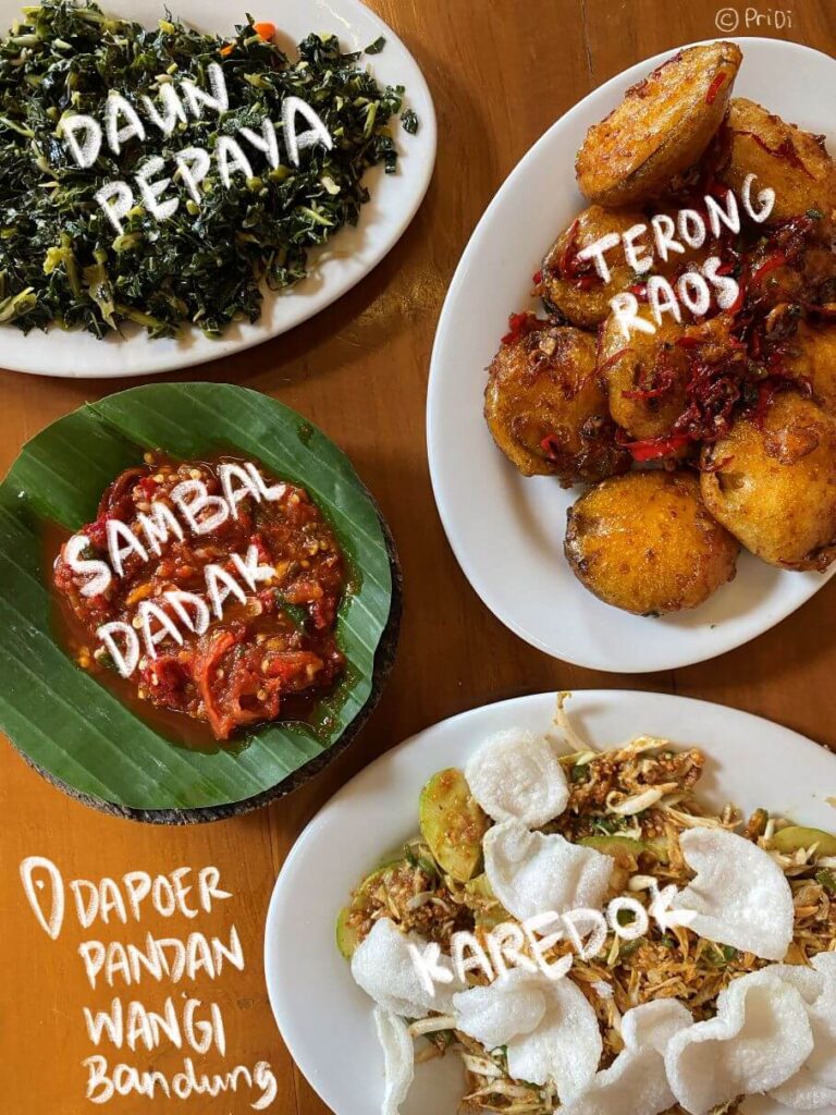 Picture of papaya leaves, fried eggplants, sambal dadak, and karedok at Pandan Wangi Restaurant Bandung