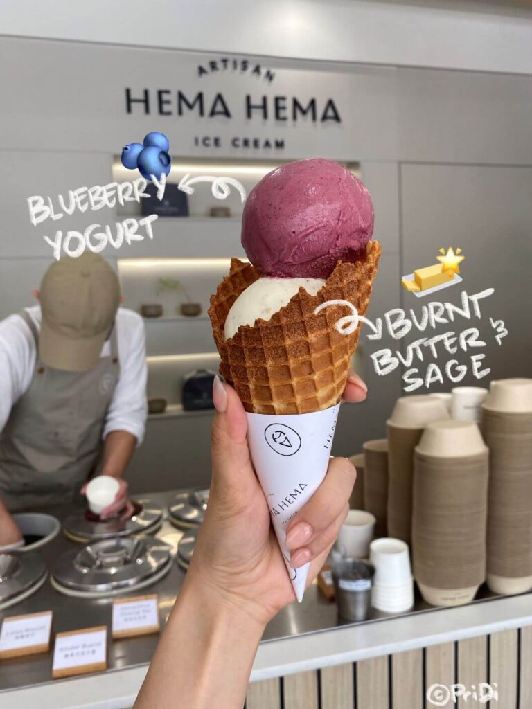 two scoops of ice cream in a cone, colored purple and cream