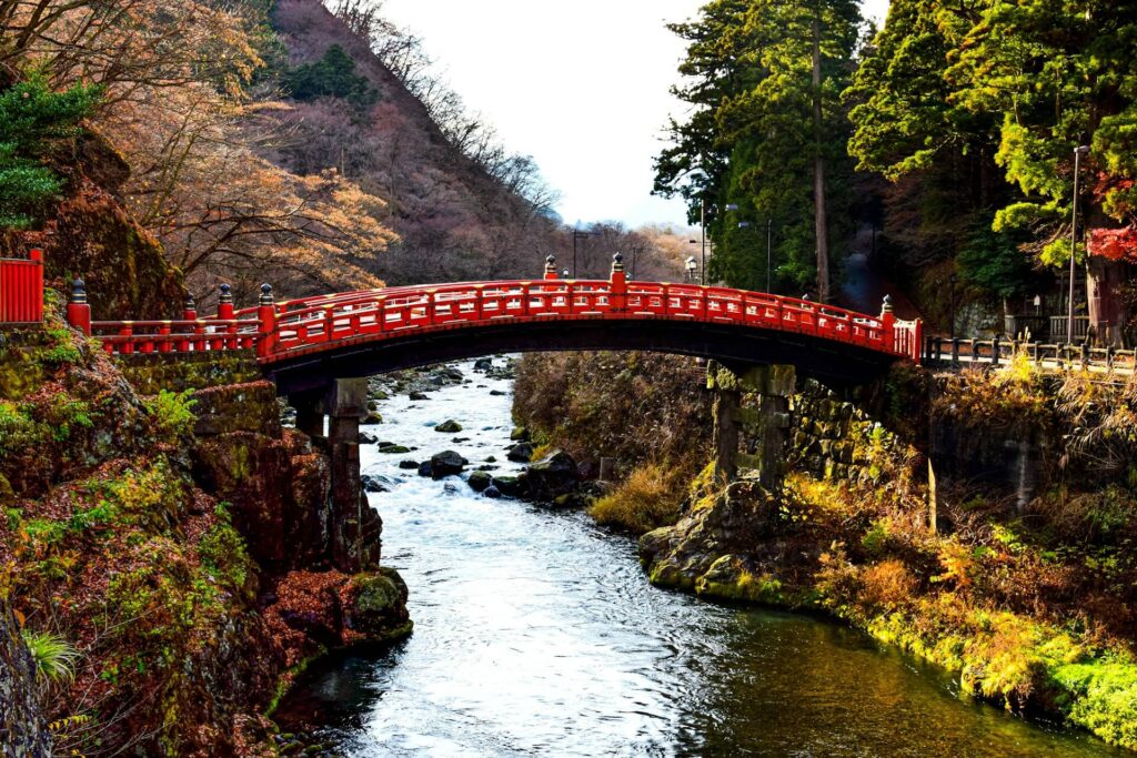 red bridge on top of a moving stream in Nikko Japan