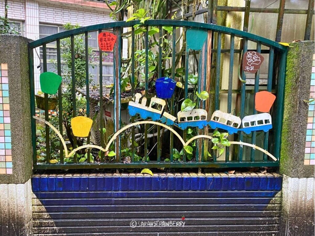 Elementary school railing in Shifen depicting colorful lanterns and trains