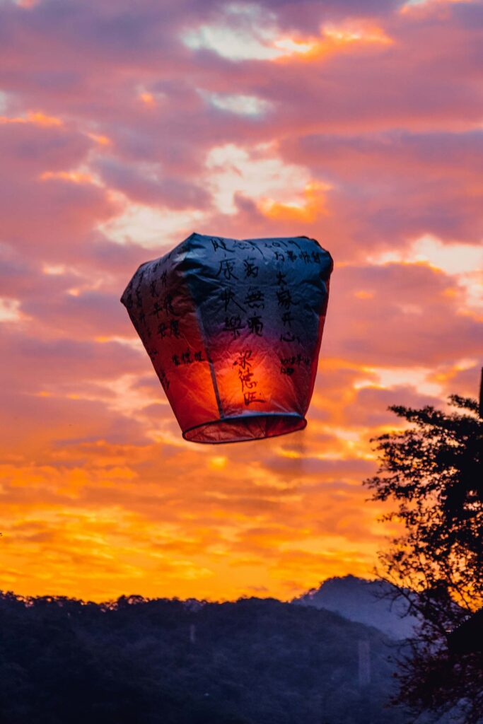 Wishing lantern floating on a sunset sky